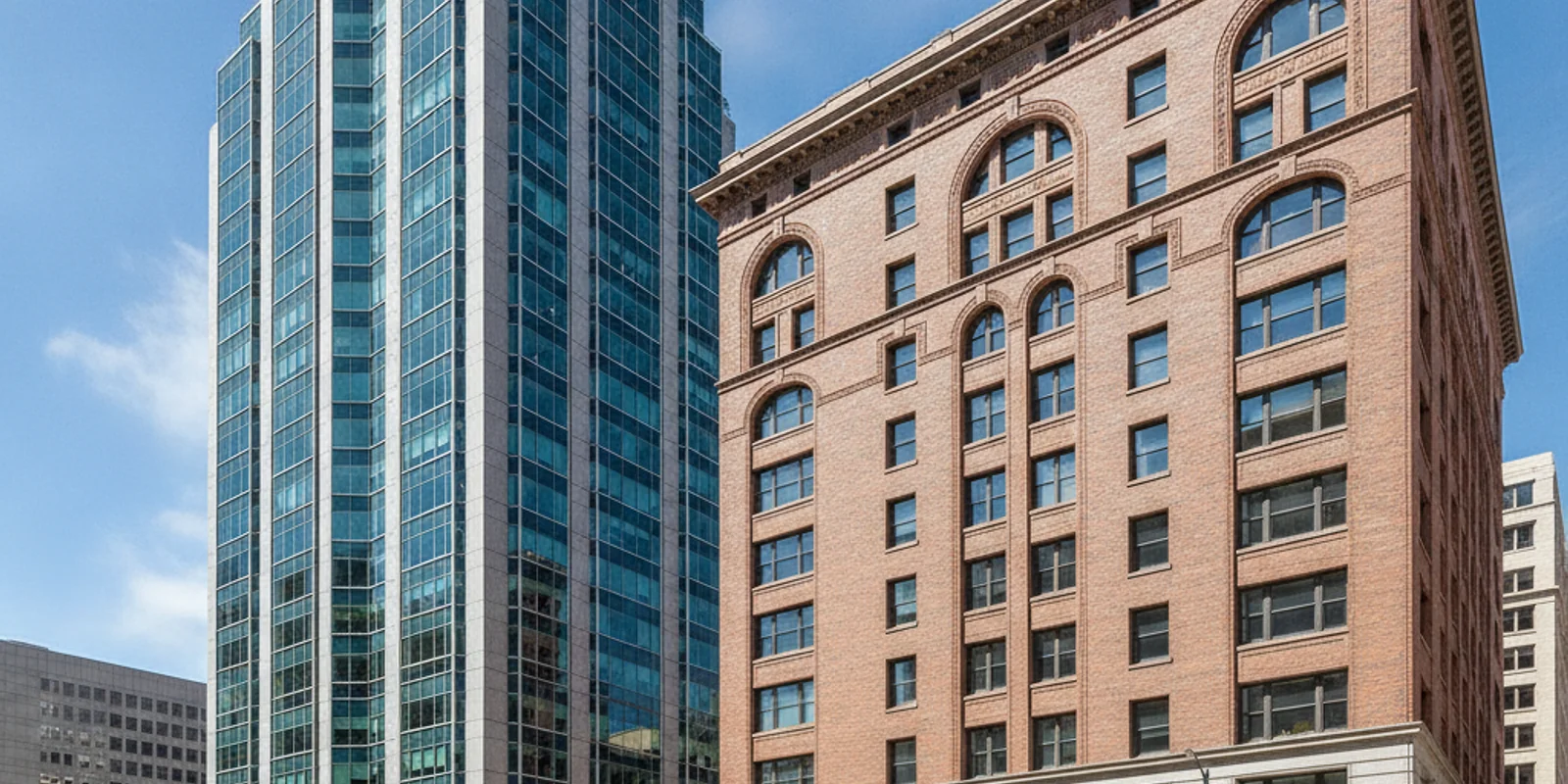 Modern glass tower beside an older brick office building in San Francisco
